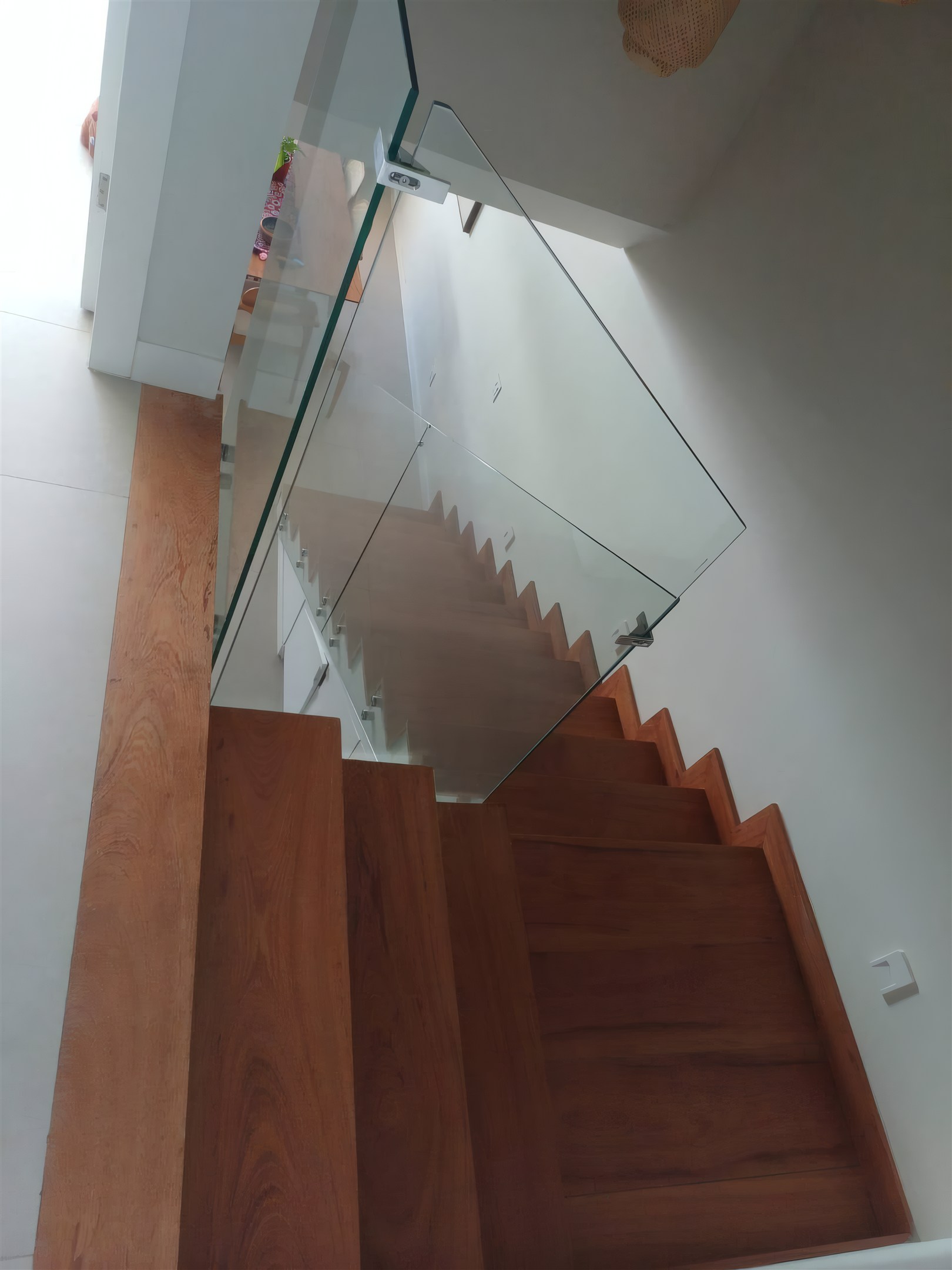 Escada interna com guarda-corpo de vidro, obra da Valuà Engenharia